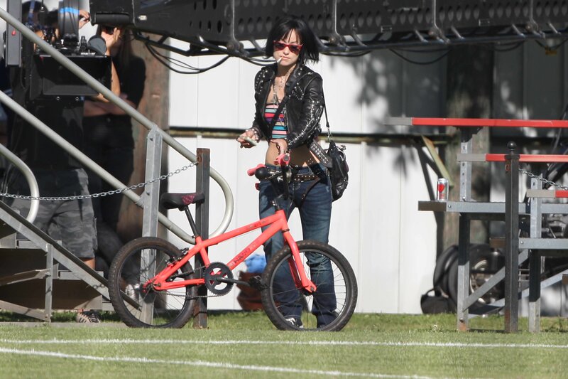 Woman with red bicycle on field