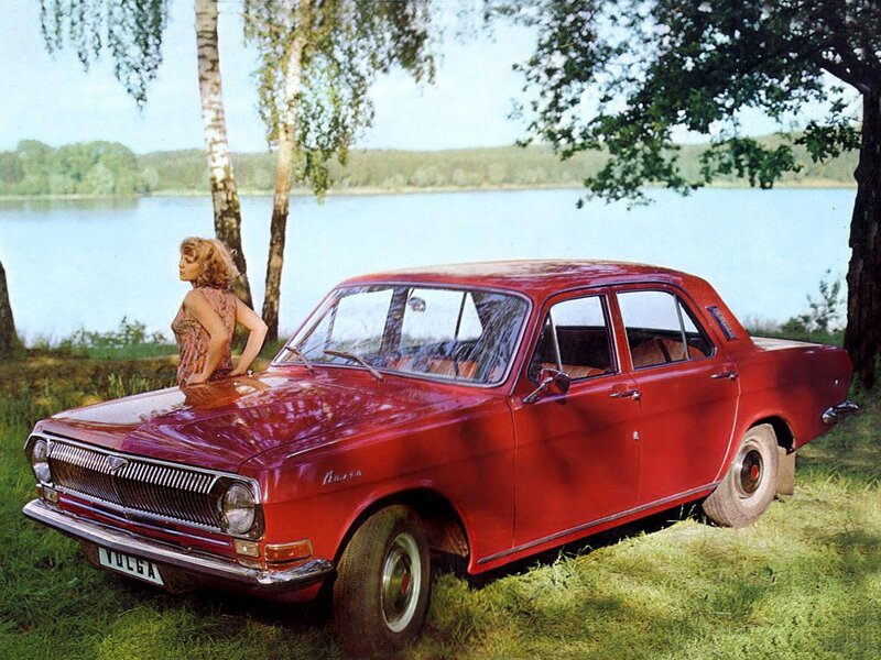 Woman with red car by lake
