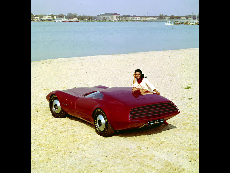 Woman with red concept car on beach