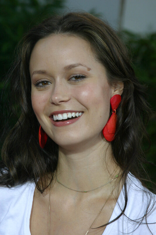 woman with red earrings smiling