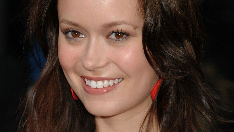 woman with red earrings smiling