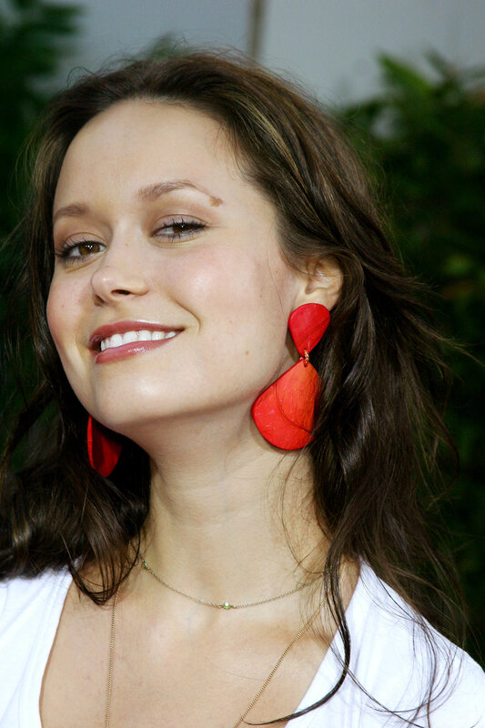 woman with red earrings smiling