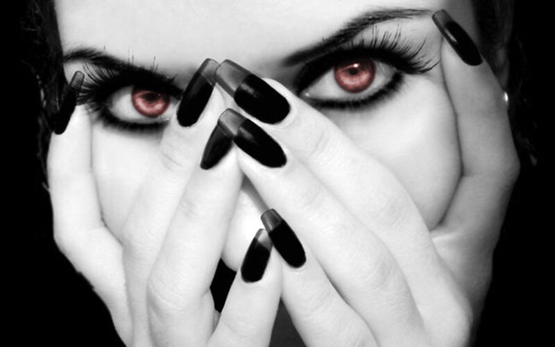 woman with red eyes and black nails