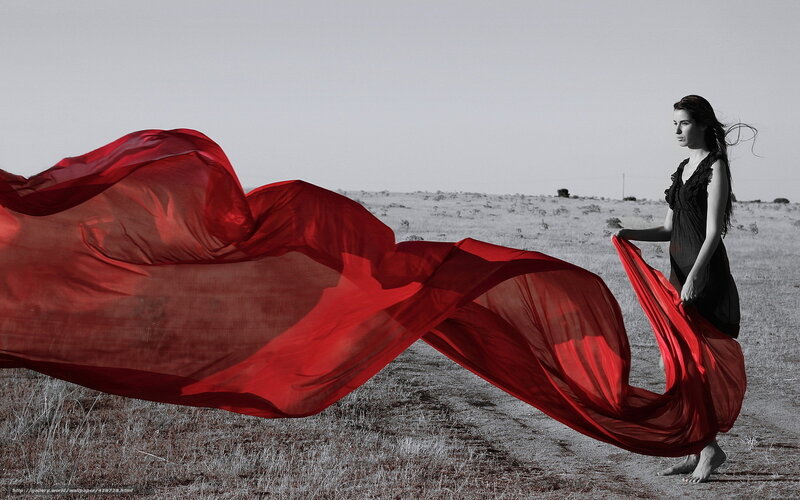 Woman with red fabric in field