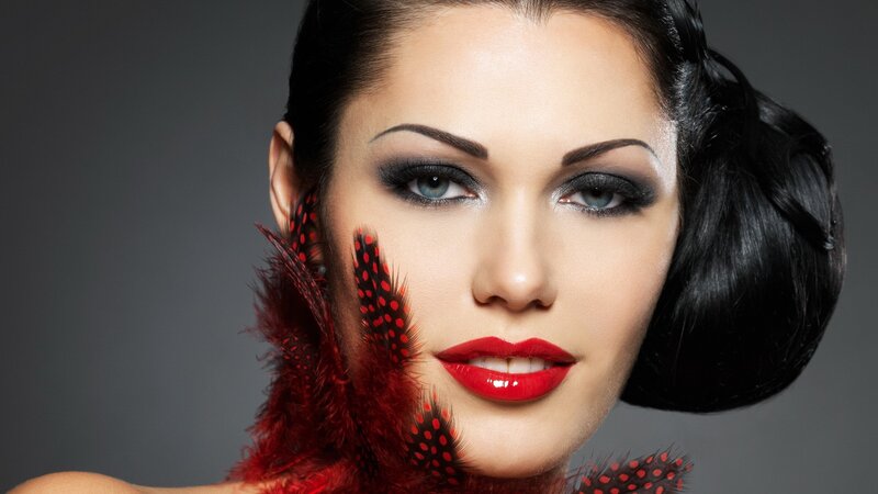 woman with red feathers and makeup