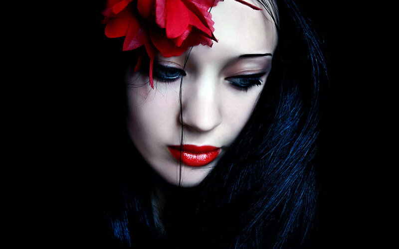 woman with red flower and makeup