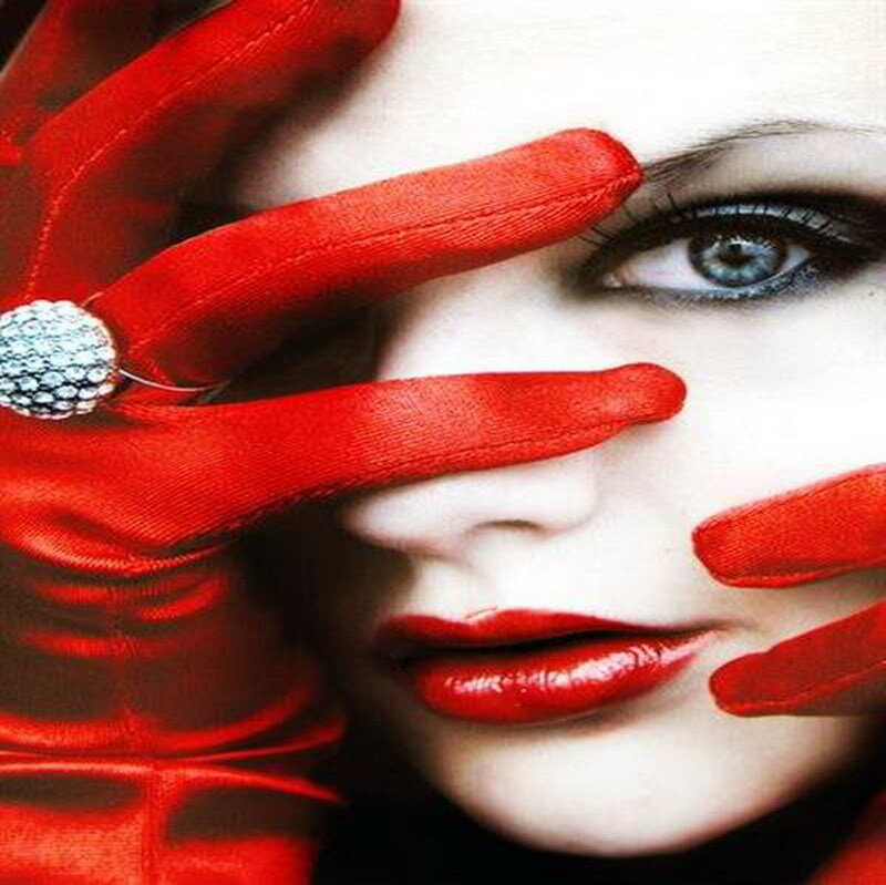woman with red gloves covering face