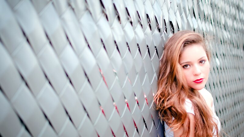 woman with red hair against metal wall