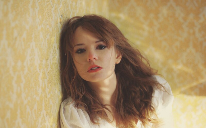 woman with red hair against wallpaper