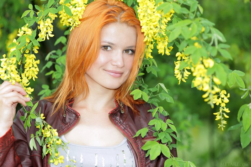 Woman with red hair among yellow flowers