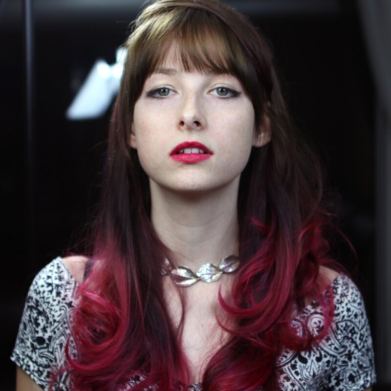 woman with red hair and bold makeup