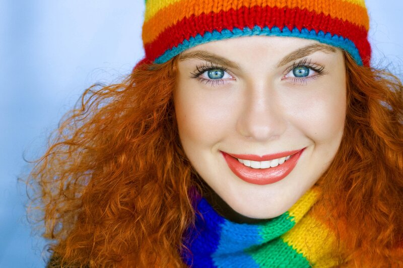 woman with red hair and colorful hat