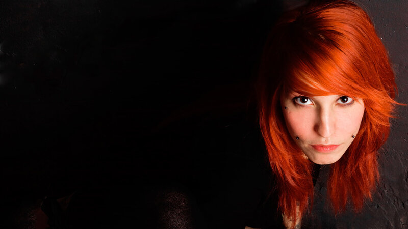 woman with red hair and facial piercings