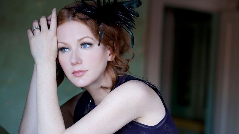 woman with red hair and feather headpiece