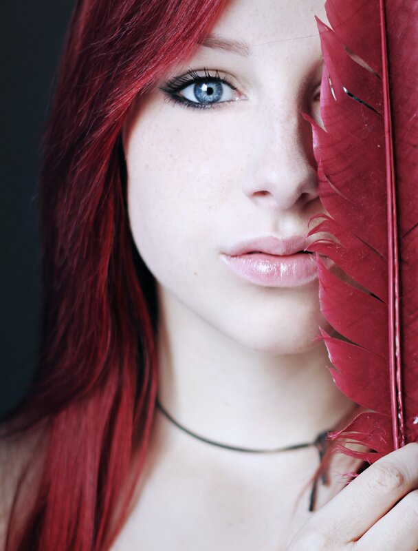 woman with red hair and feather