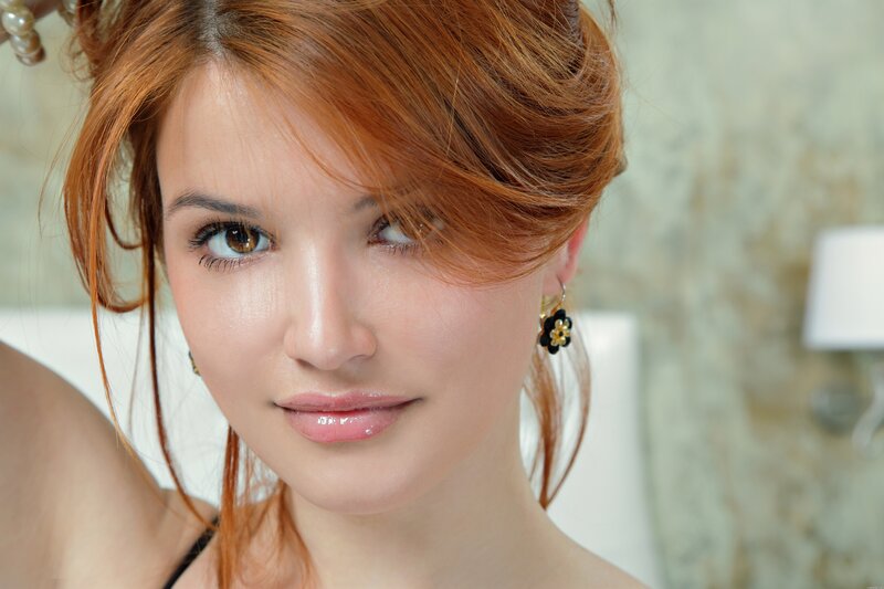 woman with red hair and flower earrings