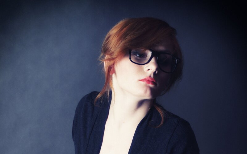 woman with red hair and glasses