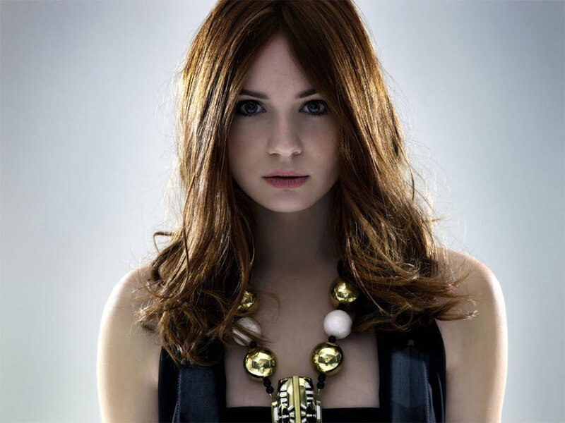 woman with red hair and gold necklace