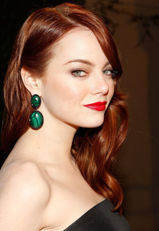 woman with red hair and green earrings