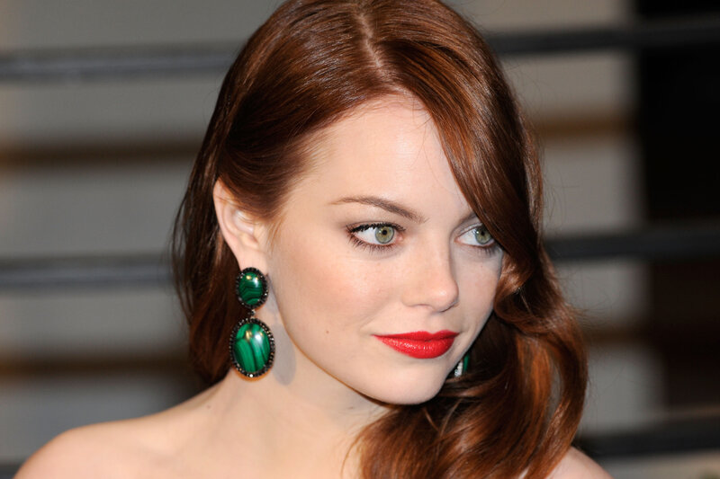 woman with red hair and green earrings