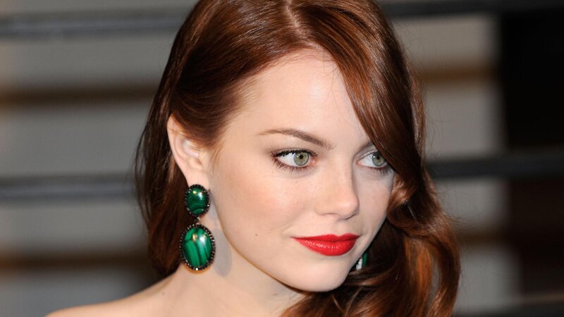 woman with red hair and green earrings