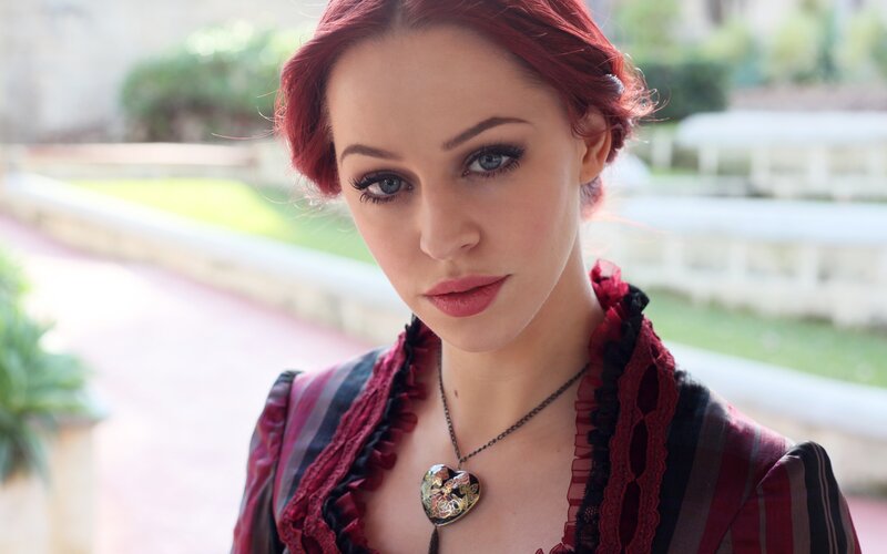 woman with red hair and heart pendant