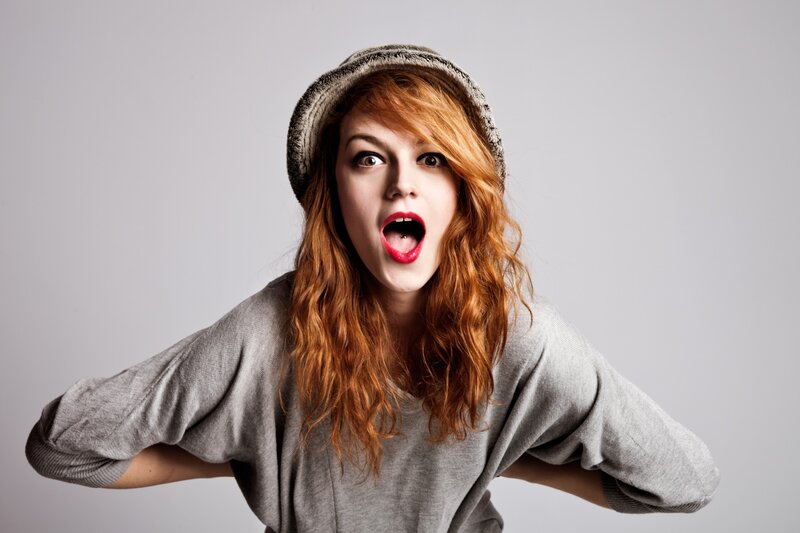 woman with red hair and surprised expression