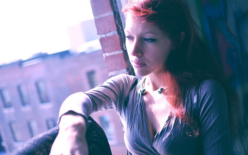 woman with red hair at window