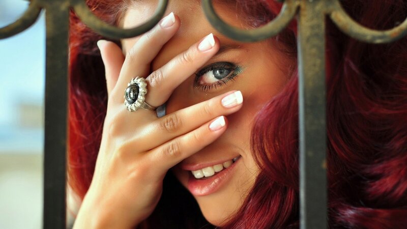 woman with red hair behind bars