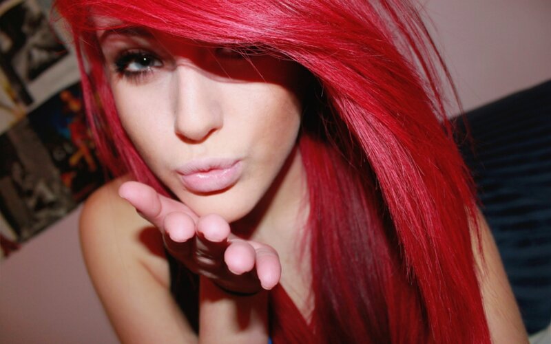 woman with red hair blowing a kiss