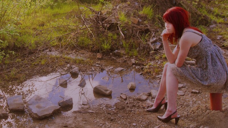 Woman with red hair by a puddle
