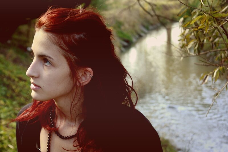 woman with red hair by a river