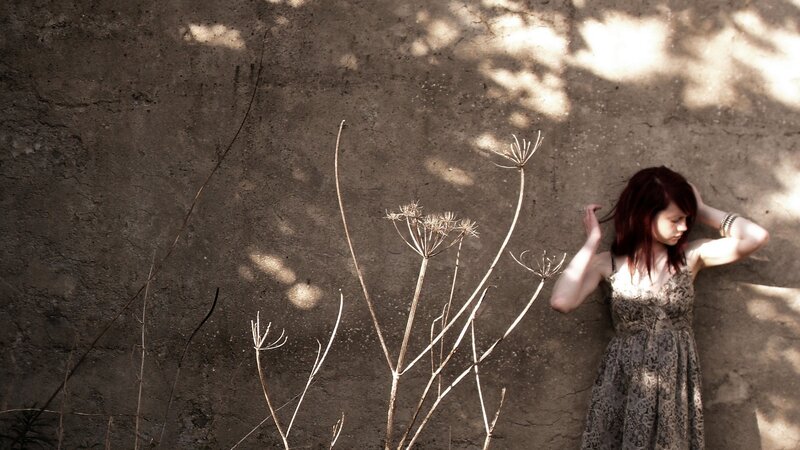 Woman with red hair by a wall