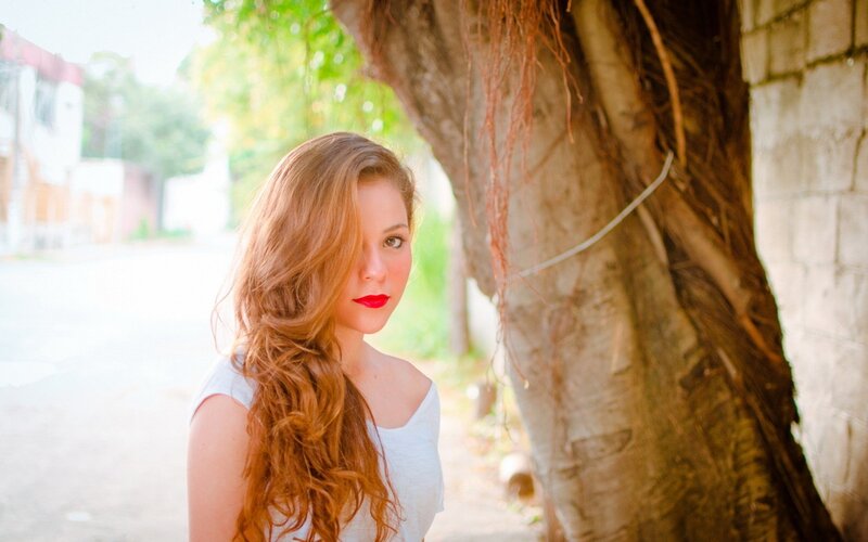 woman with red hair by tree