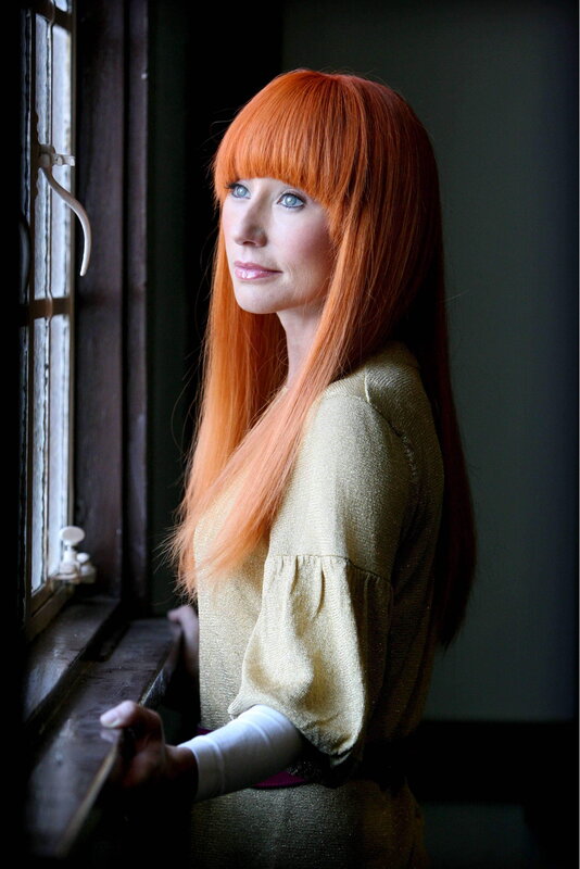 woman with red hair by window