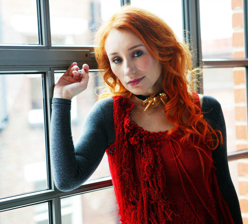 woman with red hair by window