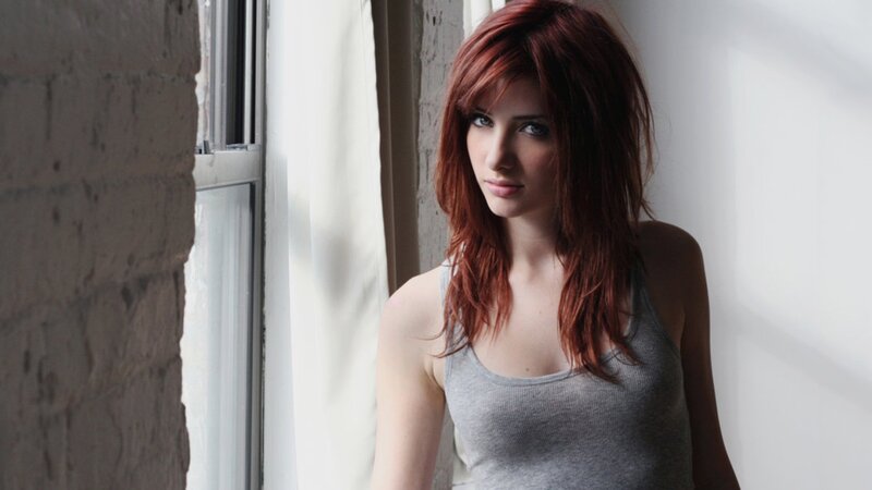 woman with red hair by window