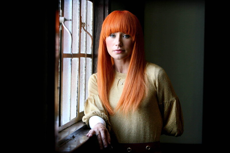 woman with red hair by window