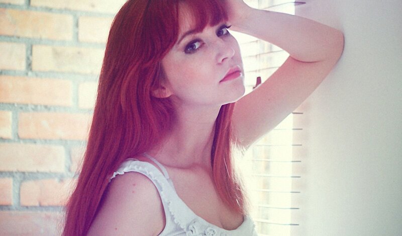 woman with red hair by window