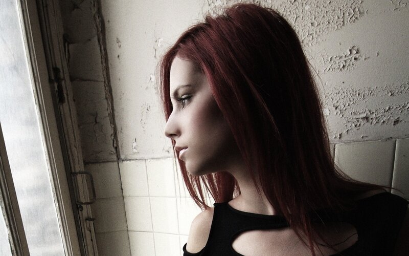 woman with red hair by window