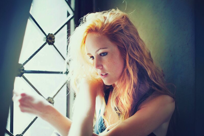 woman with red hair by window