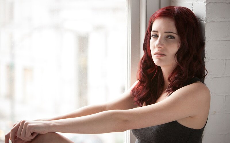 woman with red hair by window