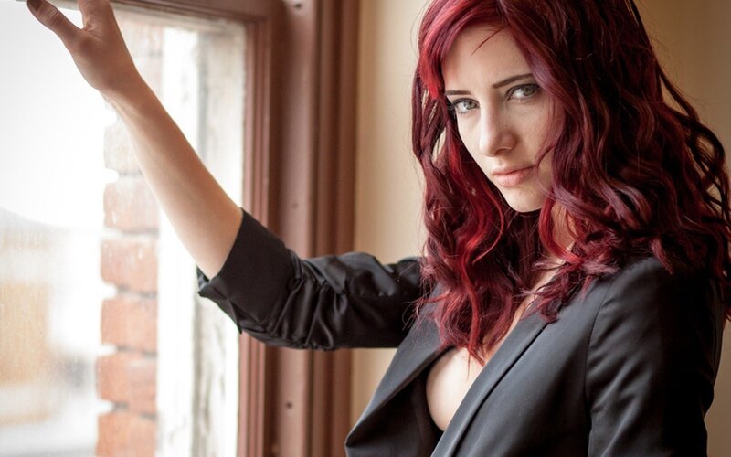 woman with red hair by window