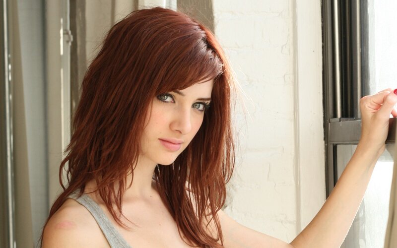 woman with red hair by window