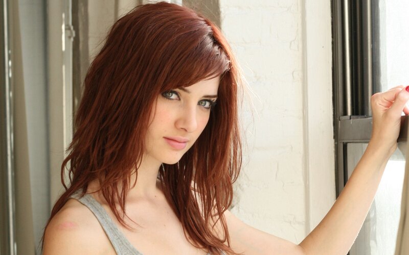woman with red hair by window