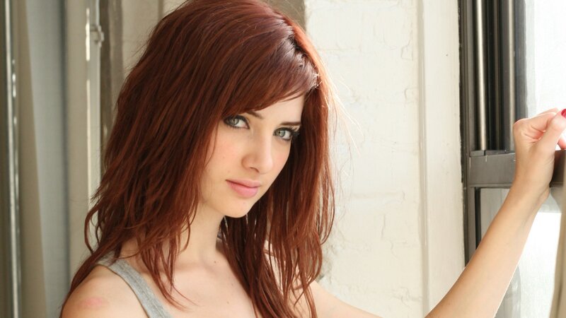 woman with red hair by window