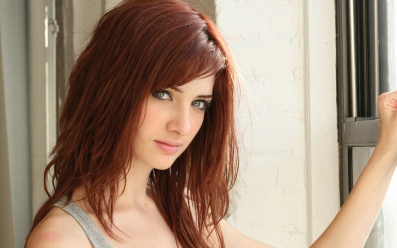 woman with red hair by window