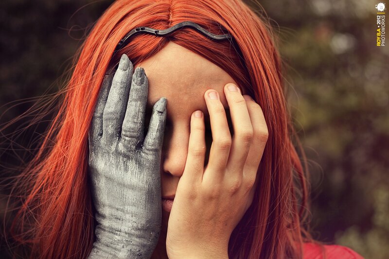 woman with red hair covering face