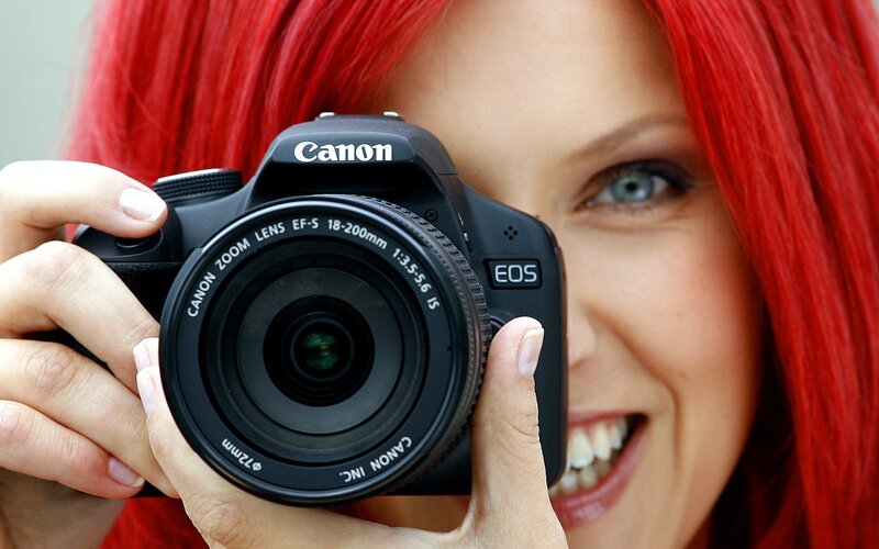 woman with red hair holding camera