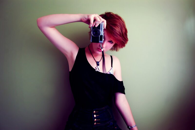 woman with red hair holding camera